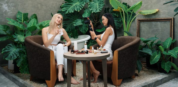 Two beautiful content creator making natural beauty and cosmetic tutorial on green garden. Beauty blogger show how to beauty care video to social medial audience using selfie stick.Panorama Blithe