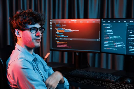 Profile of smiling IT developer sitting against software development information on screen, looking at camera surrounded by creating program coding for latest version application on website. Gusher.