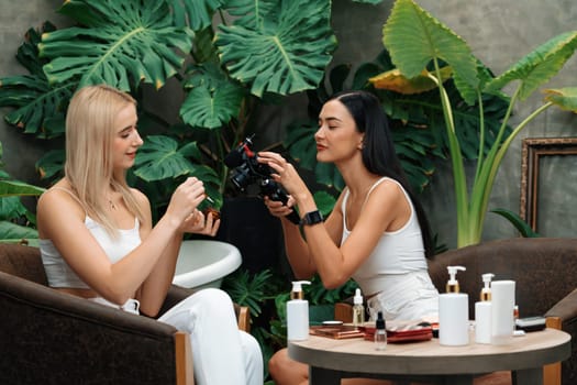 Two beautiful content creator making natural beauty and cosmetic tutorial on green plant garden video. Beauty blogger showing how to beauty care to social medial audience using selfie stick . Blithe