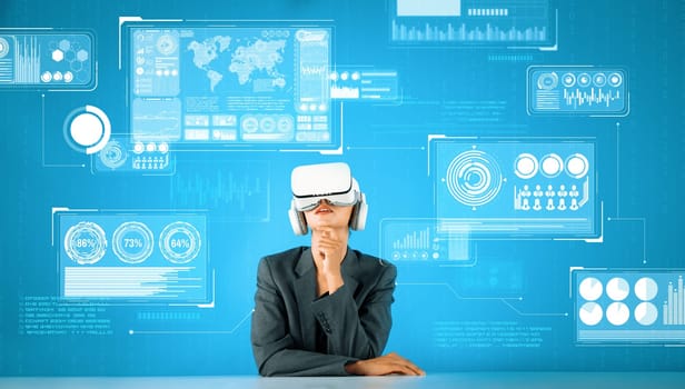Caucasian business woman with VR goggles while looking at hologram of financial graph. Professional project manager sitting while thinking and making an decision while coding program. Contraption.