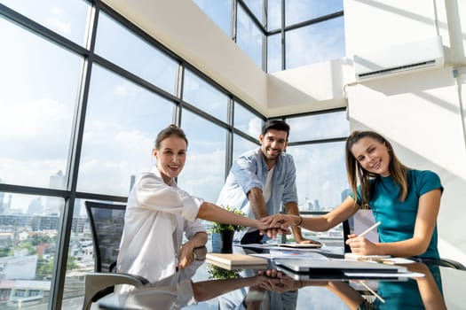 Group of skilled businesspeople putting hands together at modern office.Happy smart business team working together. Represented unity, love, team, working together, partnership, work place. Tracery.