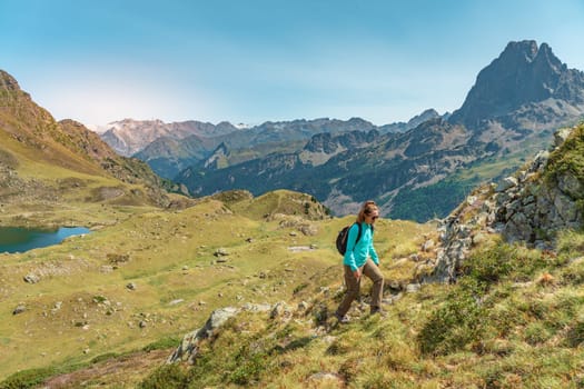 Young Attractive Woman With A Backpack hiking in a beautiful valley between mountains during the sunset. Discovery Travel Destination Concept. High quality photo