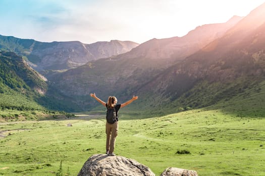 Female hiker in top of a rock with arms raised enjoying amazing landscape in summer. High quality photo.