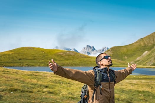 Young traveler with backpack raised arms hiking outdoor happy. Travel Lifestyle Adventure concept. High quality photo