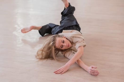 Caucasian woman dancing contemporary on the floor in a ballet class