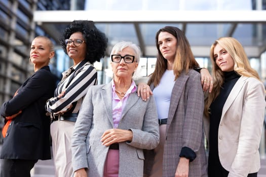 businesswomen standing side by side with their arms crossed looking at the camera smiling. Suitable for team, friendship and diversity concepts.