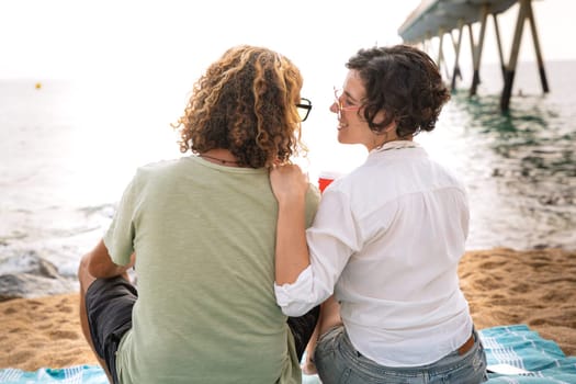 Smiling couple with sunglasses enjoying a vacation looking at the sea.