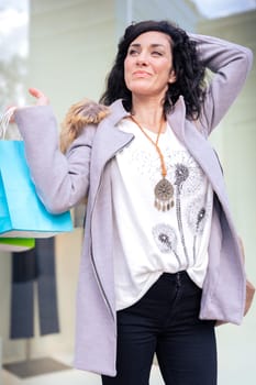 Vertical portrait Woman shopping. Happy woman with shopping bags enjoying shopping. Consumerism, shopping, lifestyle concept