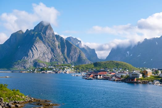 A picturesque village nestled amidst towering mountains and a calm fjord in Norway. Reine, Lofoten, Norway