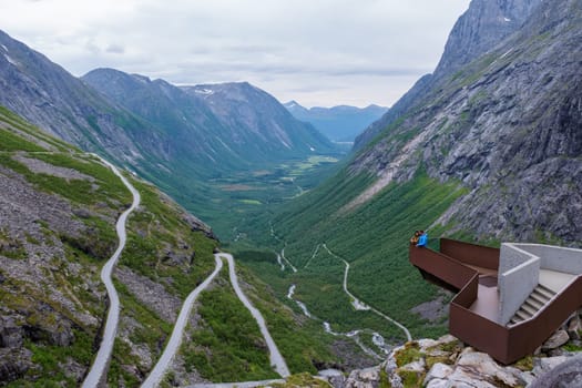 A view from a lookout point in Norway, showcasing a winding road snaking through a mountainous valley. Trollstigen Road Norway