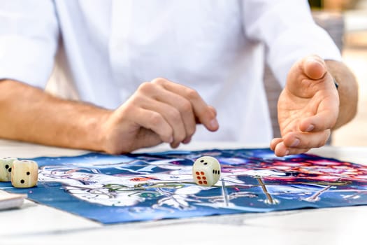 Man Playing Ancient Indian Board Game Leela: Spiritual Dice Roll, Close-up of men's Hands, Turkey, Alanya - April 14, 2024