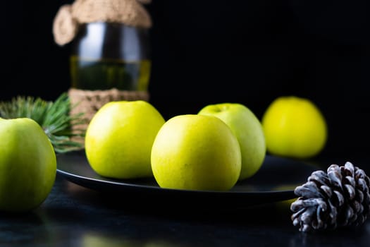 Fresh ripe green apples on a wooden table against dark background, space for text