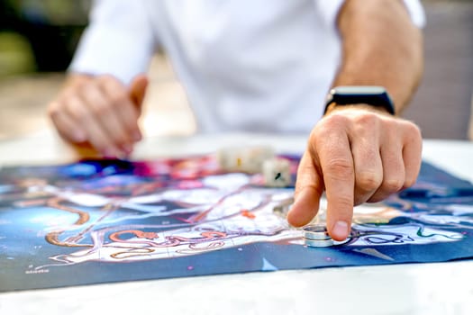 Close-Up of Hands with Game Chip in Form of Ring, Man Makes Move After Rolling Dice on Game Board of Ancient Indian Game Leela, Turkey, Alanya - April 14, 2024