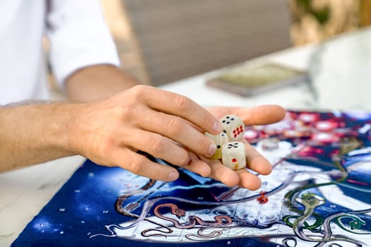 Ancient Indian Game Leela: Close-Up of Men's Hands with Onyx Dice Zar on Game Board, Turkey, Alanya - April 14, 2024