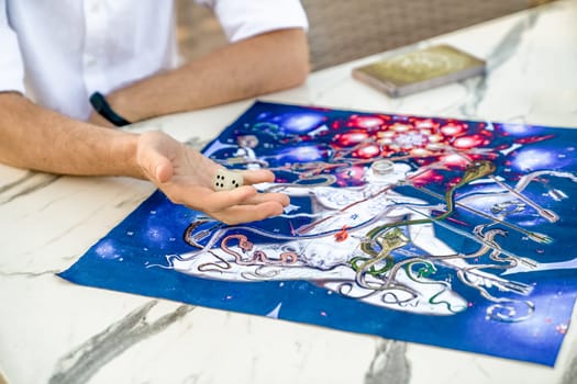 Board Game: Close-up of men's Hands with jade Dice Zar and Game Board from the Ancient Indian Game Leela, Turkey, Alanya - April 14, 2024