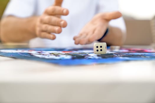 Man's Hand Throws Die onto Paying Field, Close-up, Copy Space.