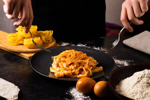 Hand uses chopsticks to pickup tasty noodles. Asian meal on table, junk food concept