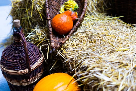 Orange halloween pumpkins on stack of hay or straw in a sunny day, fall display