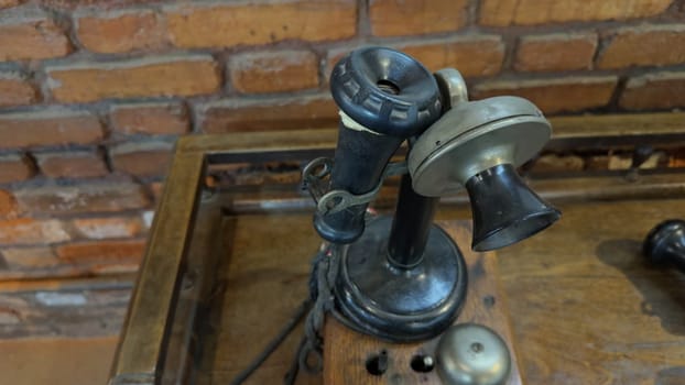 A hand reaches for an old vintage phone but hesitates and decides not to pick it up, all captured in a close-up video.