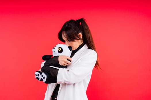 Portrait of cute woman posing in a studio with panda