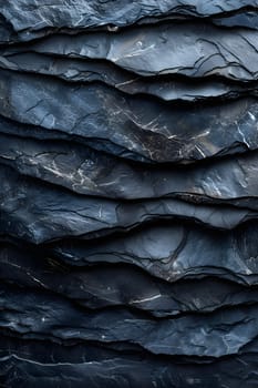 A close up of a stack of grey rocks arranged on top of each other, resembling a pattern, set against a freezing landscape with an electric blue sky