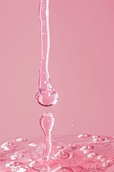 Pink liquid drop falling in water on pink background beauty in motion and colorful tranquility