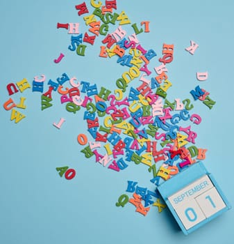 Scattered wooden letters on a yellow background, top view