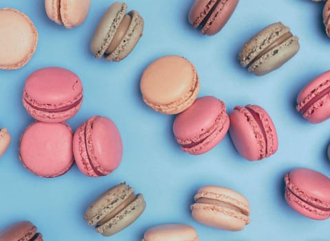 Multicolored macarons on a blue background, top view, dessert