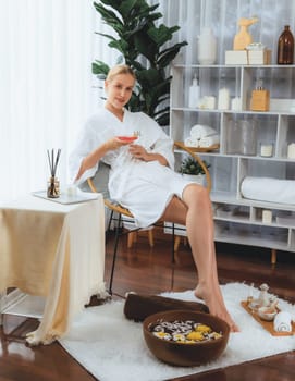 Woman indulges in blissful foot massage at luxurious spa salon while masseur give reflexology therapy in gentle day light ambiance resort or hotel foot spa. Quiescent