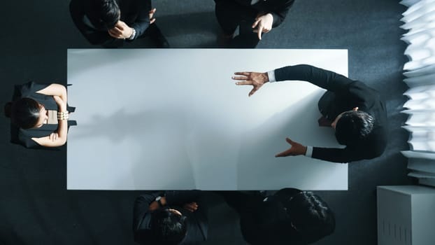 Top down aerial view of smart cooperate businessman discussing about marketing strategy. Diverse business group brainstorming idea startup project and financial plan at meeting room. Directorate.