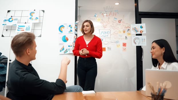 Closeup of young leader present business project with confident by using mind map and colorful sticky notes surrounded by colleague and project manager brainstorming about project. Immaculate.