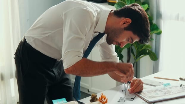 Top down view of smart architect engineer measure blueprint by using architectural equipment while interior designer thinking about building design or house construction at meeting room. Alimentation.