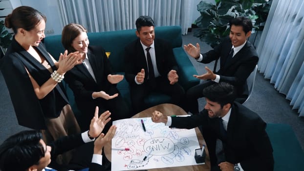 Top view of business people clapping hands to celebrate successful project while using mind map to brainstorm idea. Happy team clap handor applause successful plan while writing mind map. Directorate.