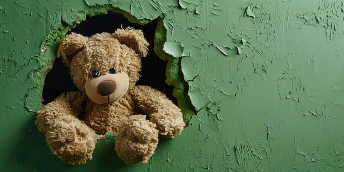 Close up view picture of the hollow green hole on the the wall that show the teddy stay inside the wall that has been made from some material yet still can be break to look through other side. AIGX03.