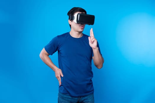 Smart gamer wearing VR turning to metaverse world playing gun shooting hunter isolated blue background connecting to victory animal hunting futuristic technology hologram virtual reality. Contrivance.