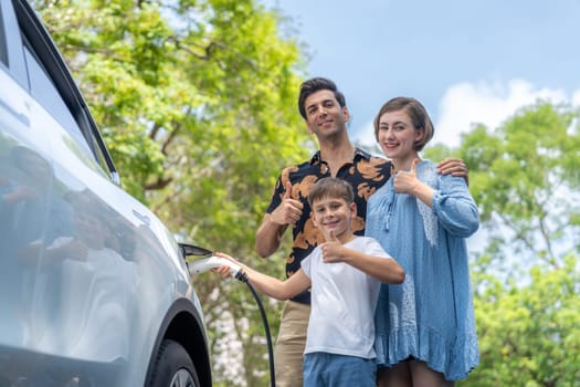 Family road trip vacation with electric vehicle, lovely family recharge EV car with green and clean energy. Natural and eco friendly car travel for sustainable environment. Perpetual