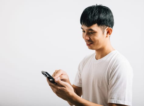 Portrait Asian smiling young man using mobile phone cellphone for social media studio isolated white background, Happy lifestyle men typing message on smartphone, mobile application online