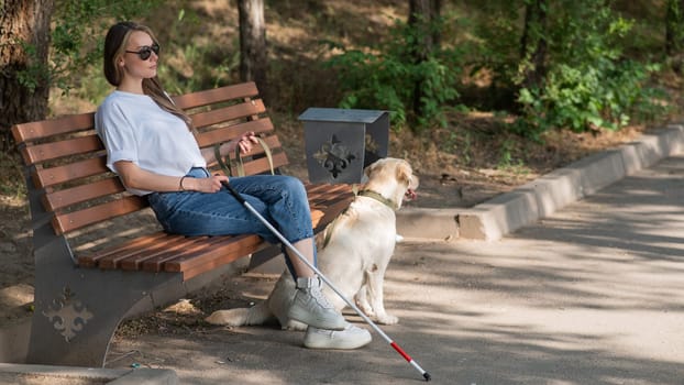 Blind caucasian woman sitting on bench with guide dog