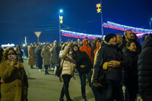 crowd of Russian people on the street are watching fireworks in a night sky in Tula, Russia - May 9, 2021