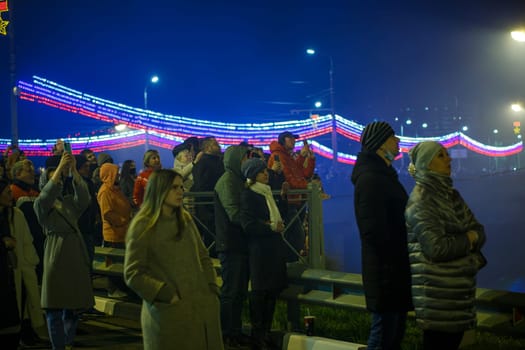 crowd of Russian people on the street are watching fireworks in a night sky in Tula, Russia - May 9, 2021