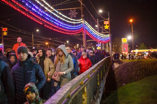 crowd of Russian people at road on the hill and bridge are watching fireworks in a night sky in Tula, Russia - May 9, 2021