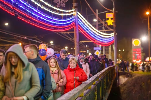 crowd of Russian people at road on the hill and bridge are watching fireworks in a night sky in Tula, Russia - May 9, 2021