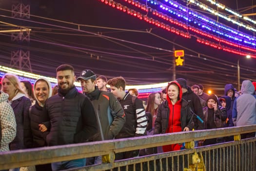 crowd of Russian people at road on the hill and bridge are watching fireworks in a night sky in Tula, Russia - May 9, 2021