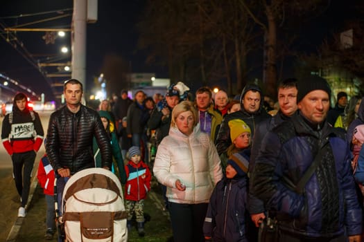 crowd of Russian people walking along the city street sidewalk at night after celebration of victory day in Tula, Russia - May 9, 2021