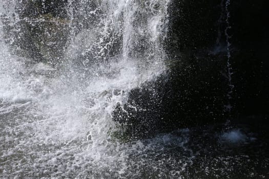 Photo of water crashing on rocks in a waterfall.