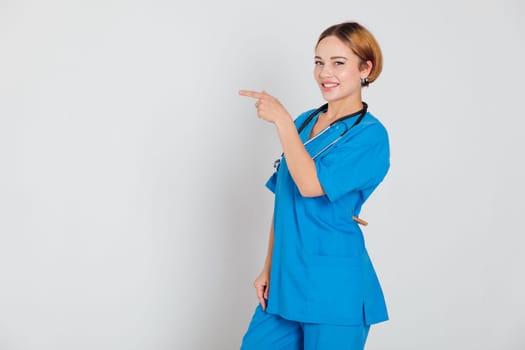 female doctor in blue suit with phonendoscope stethoscope in hospital hospital points finger direction