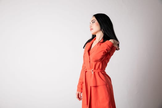 woman in an orange dress against a light wall