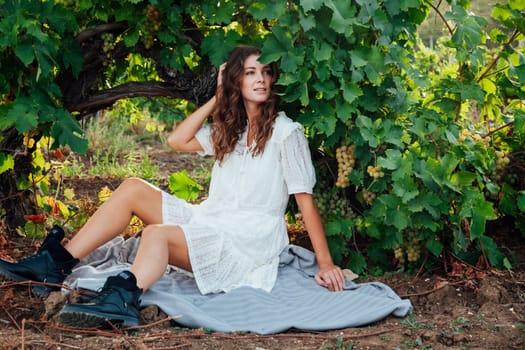 a woman sits on a mat in grape leaves