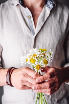 Man in Linen Shirt Holding Freshly Picked Chamomile Flowers in Hands