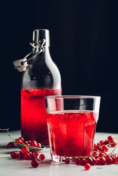 Table glass of infused water with fresh red currant